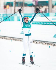 Krista Pärmäkoski tuulettaa maaliviivalla olympiamitalia.